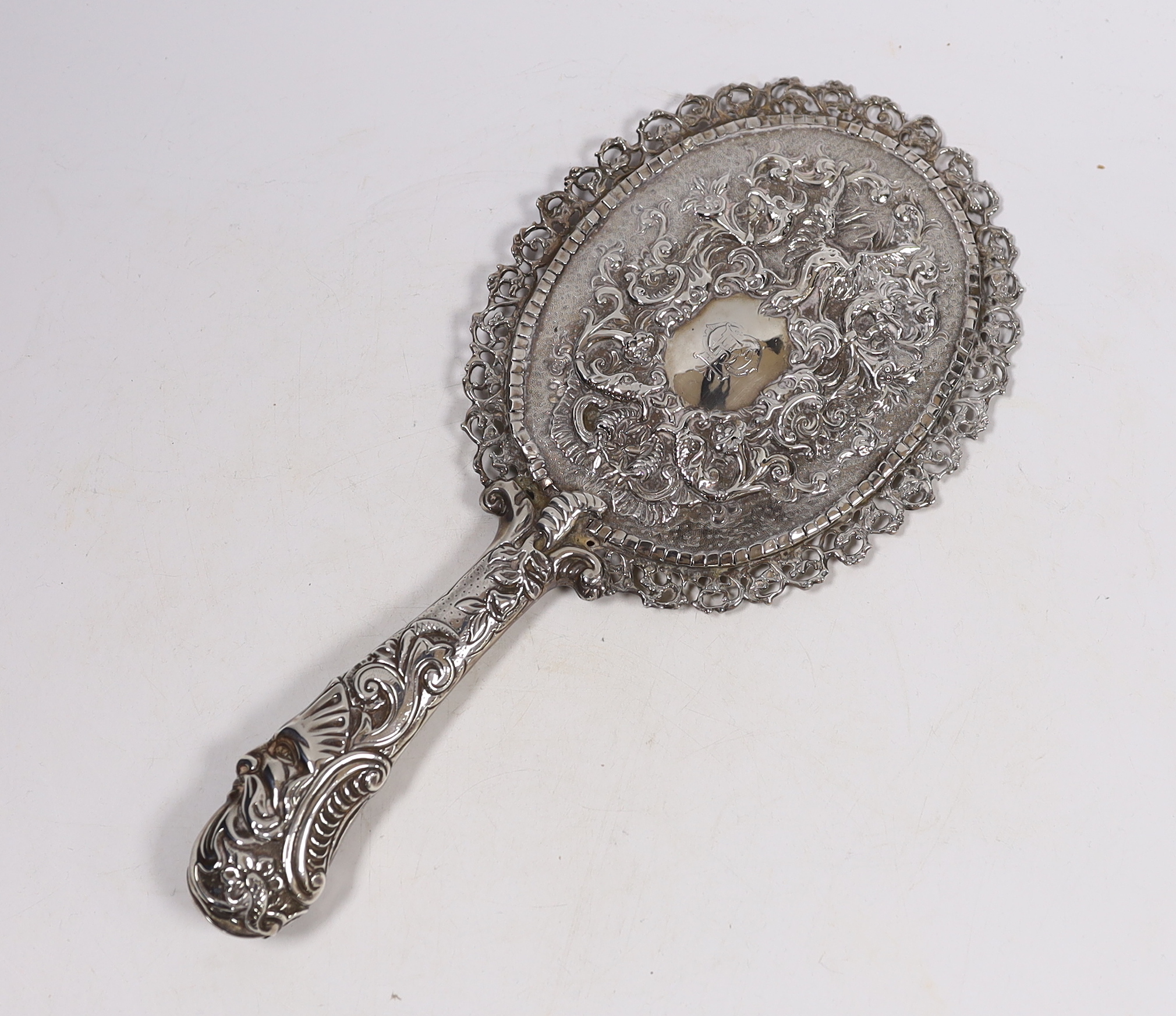 An ornate late Victorian silver mounted hand mirror, Edward Brown, London, 1891, 30.1cm.